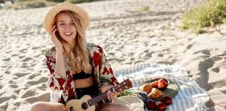 Nő gitárral a tengerparton